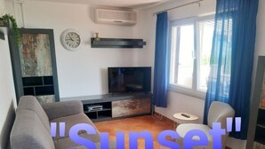 A living room with a sofa, a TV, a small table, and a window with curtains. - Apartment in Slatine with Seaview, Balcony, Air condition, WIFI (5130-1) (Slatine)