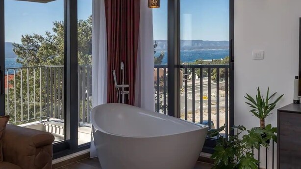 A modern bathroom with a freestanding bathtub, large windows, and a view of the outdoors. - Apartment in Bol with Seaview, Balcony, Air condition, WIFI (5127-1) (Bol)
