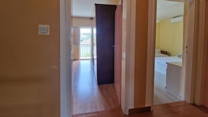 A hallway with a wooden floor leading to a room with a bed and a bathroom. - Apartment in Okrug Donji with Seaview, Terrace, Air condition, WIFI (5136-1) (Okrug Donji)