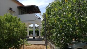 A two-story building with a covered outdoor area and a car parked nearby. - Apartment in Okrug Donji with Seaview, Terrace, Air condition, WIFI (5136-1) (Okrug Donji)
