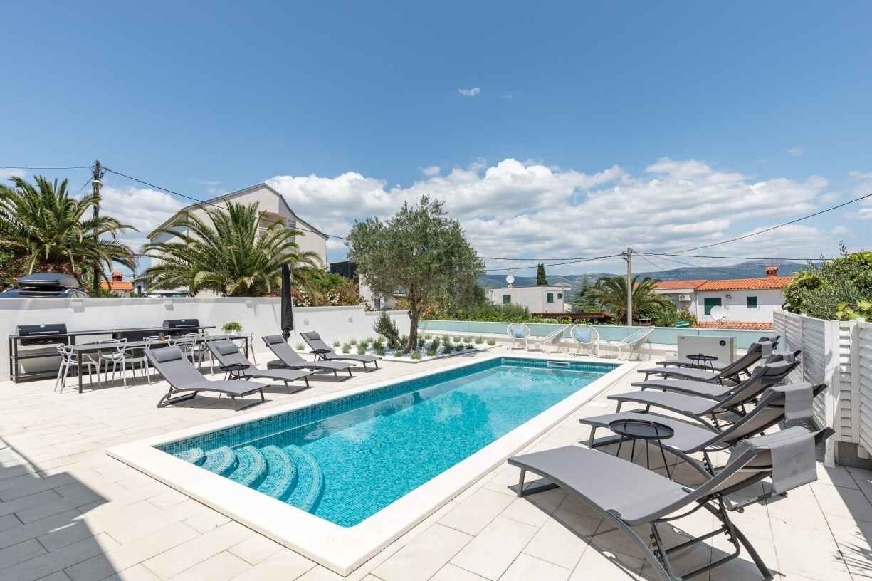A rooftop swimming pool with lounge chairs and a view of the surrounding buildings.