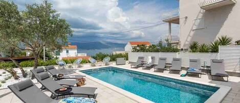 Lämmitetty uima-allas, aurinkotuoleja