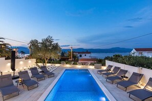 A heated pool, sun loungers