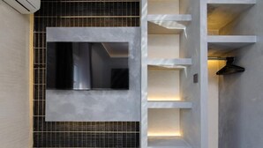 Een moderne badkamer met een grote spiegel, inbouwverlichting en een betegelde spatwand.