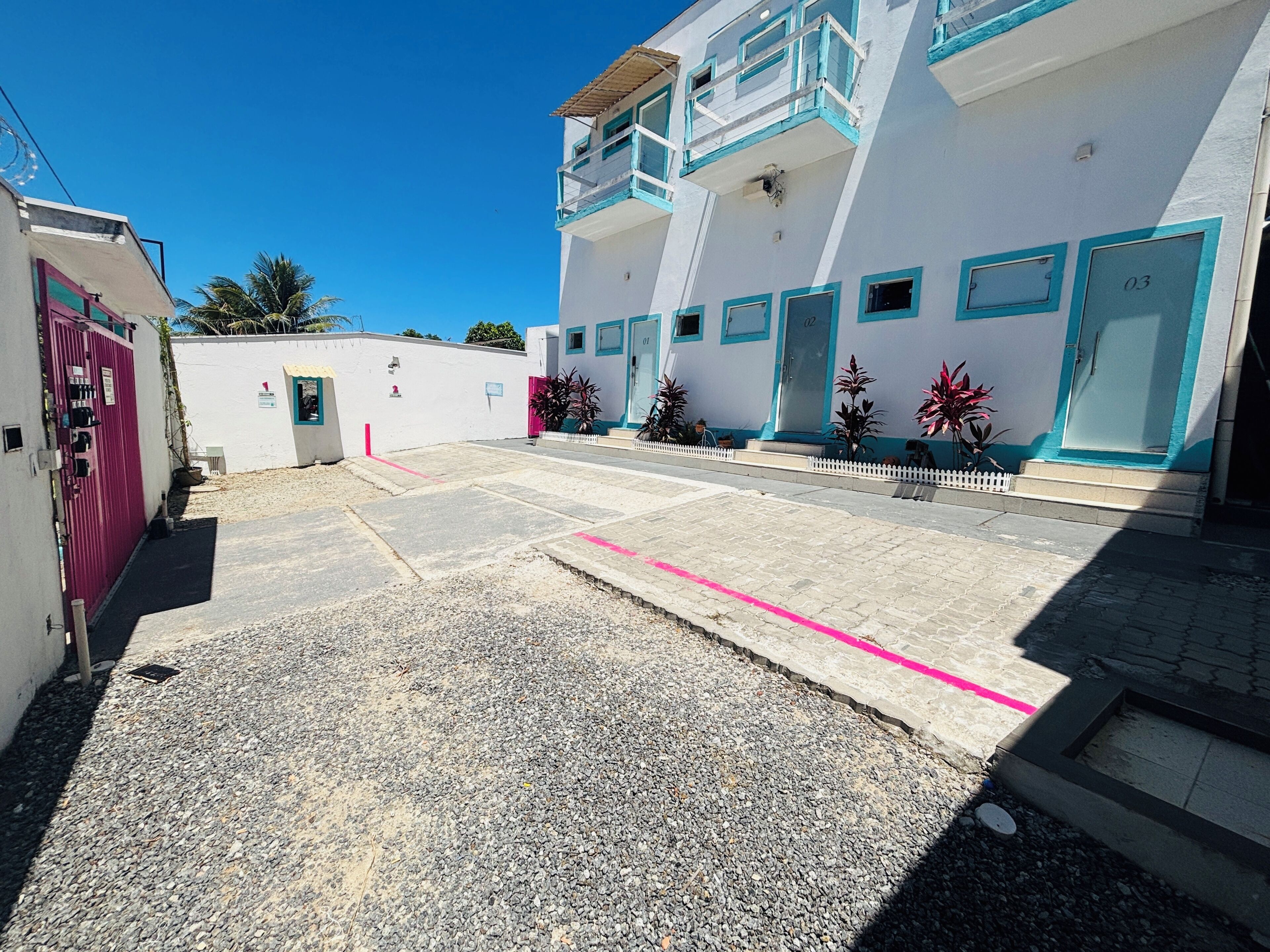 A building with numbered doors, a gated entrance, and a paved courtyard.
