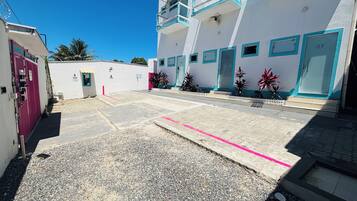 A building with numbered doors, a gated entrance, and a paved courtyard.