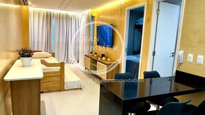 Una habitación de hotel moderna con una cama de madera, un escritorio y un comedor con sillas.