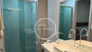 A modern bathroom with a glass shower enclosure, a white sink with a mirror, and a toilet. - Gran Summer Concept In Accommodation (Fortaleza)