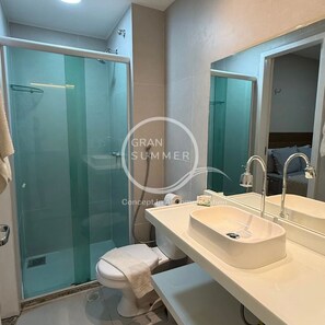 A modern bathroom with a glass shower enclosure, a white sink with a mirror, and a toilet. - Gran Summer Concept In Accommodation (Fortaleza)