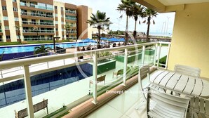 A balcony with a view of a swimming pool and a hotel building. - Gran Summer Concept In Accommodation (Fortaleza)