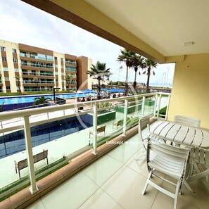 A balcony with a view of a swimming pool and a hotel building. - Gran Summer Concept In Accommodation (Fortaleza)