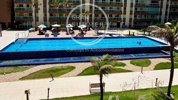 A hotel with a swimming pool, outdoor seating, and palm trees. - Gran Summer Concept In Accommodation (Fortaleza)