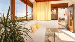A modern room with a wooden ceiling, large windows, a sofa with cushions, a small table, and potted plants. - Apartment in Primošten with Seaview, Terrace, Air condition, WIFI (5155-1) (Primošten)