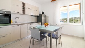 A modern kitchen with a dining area, a refrigerator, and a window with a view. - Apartment in Primošten with Seaview, Terrace, Air condition, WIFI (5155-1) (Primošten)
