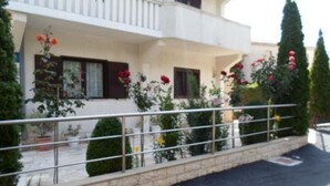 A two-story building with balconies, a paved driveway, and potted plants. - Apartment in Rogoznica with Seaview, Balcony, Air condition, WIFI (5153-2) (Rogoznica)