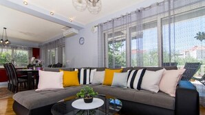 A modern living room with a sectional sofa, a glass coffee table, and large windows. - Apartment in Okrug Gornji with Terrace, Air condition, WIFI, Washing machine (5157-1) (Okrug Gornji)