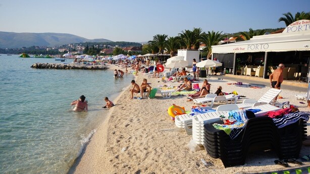 A beach with clear water, umbrellas, and lounge chairs. There are people swimming and relaxing on the sand. - Apartment in Okrug Gornji with Terrace, Air condition, WIFI, Washing machine (5157-1) (Okrug Gornji)