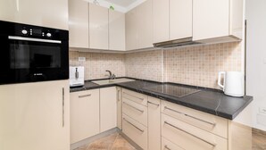 A modern kitchen with beige cabinets, a black countertop, and a Bosch refrigerator. - Apartment in Medulin with Terrace, Air condition, WIFI, Washing machine (5158-2) (Medulin)