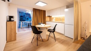 A modern kitchen with a dining area, a coffee machine, and a view of the outside. - Studio apartment in Mastrinka with Loggia, Air condition, WIFI (5159-2) (Mastrinka)