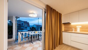 A modern kitchen with a wooden countertop, a built-in oven, and a window overlooking a residential area. - Studio apartment in Mastrinka with Loggia, Air condition, WIFI (5159-2) (Mastrinka)
