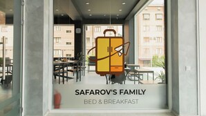 Een restaurant met een groot raam en een bord waarop staat: SAFAROV'S FAMILY BED & BREAKFAST.