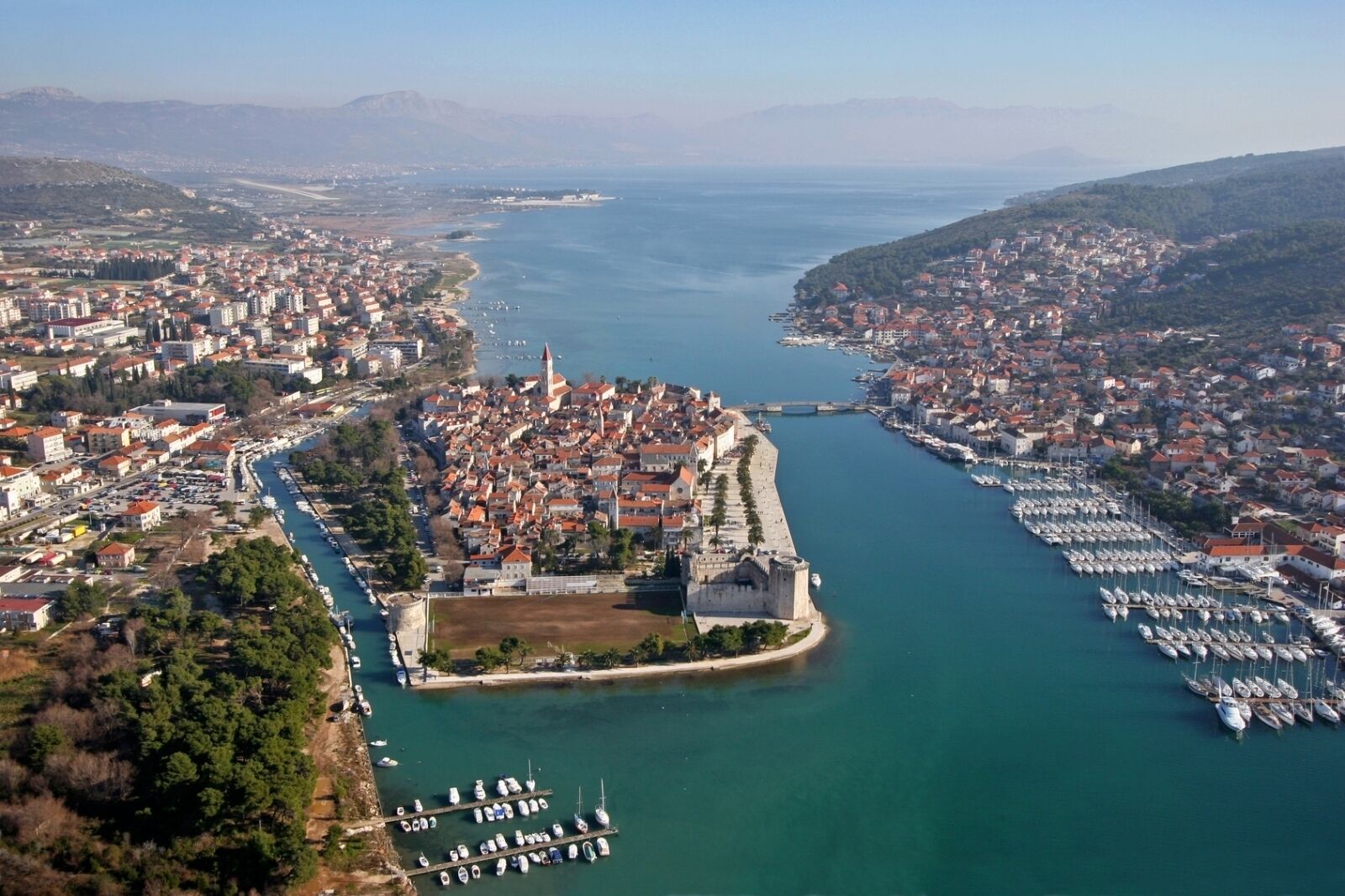 A coastal city with a fortified historic center, marina, and residential areas.