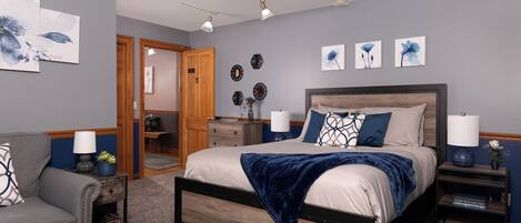 A bedroom with a bed, bedside tables, a chair, and a ceiling fan.
