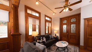 A living room with a sectional sofa, a coffee table, and a ceiling fan. - Hotel Galena (Galena)