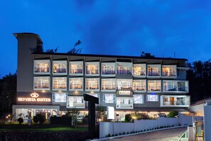 Un hotel de varios pisos con un llamativo letrero que dice 'Skivista Suites', balcones e iluminación frontal.