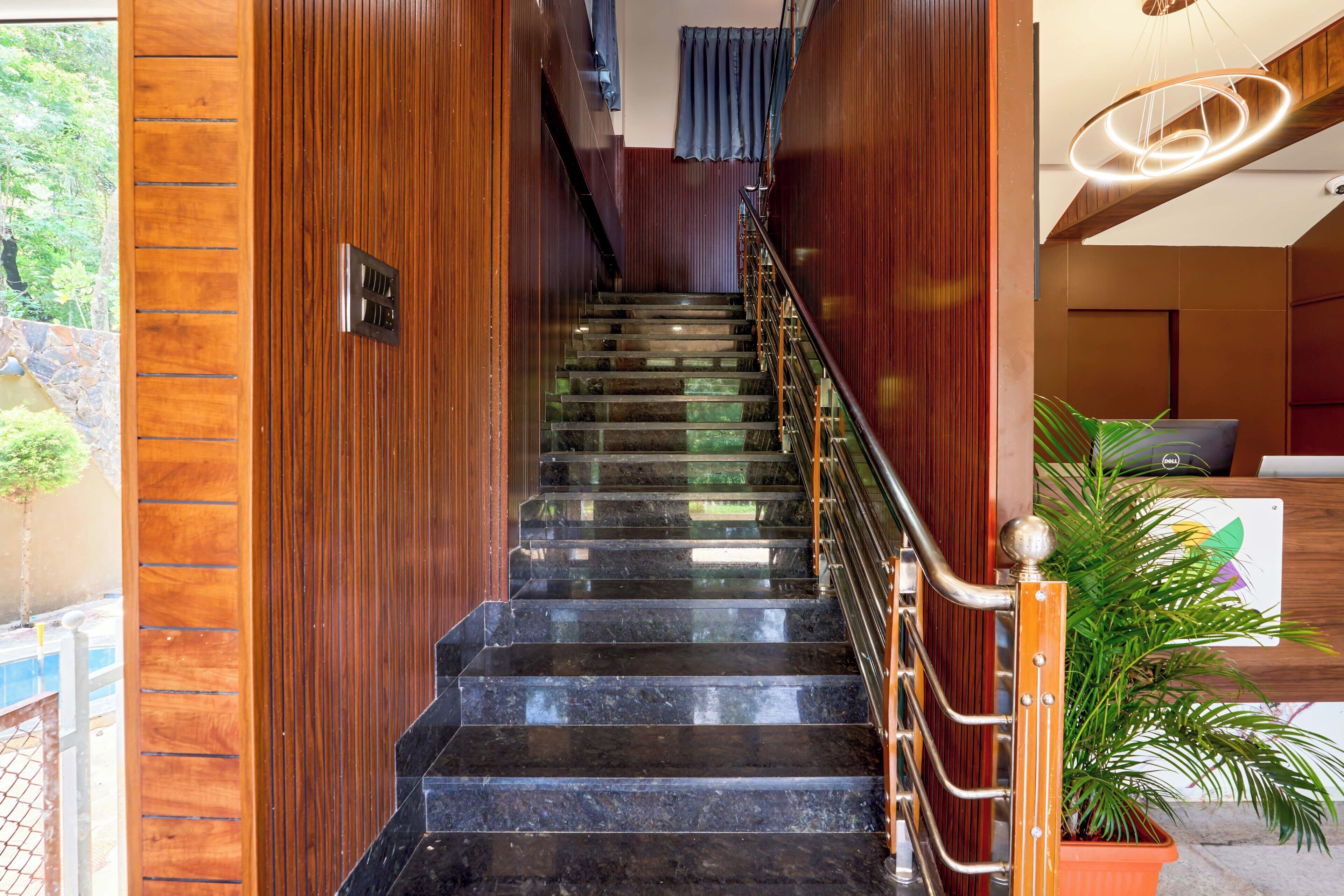 A staircase with wooden paneling and a metal railing, leading to a room with a modern design.