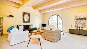 A spacious living room with a high ceiling, a large arched window, and a modern fireplace. - Two-story Luxury in Siena Resort at Lemon (Trequanda)