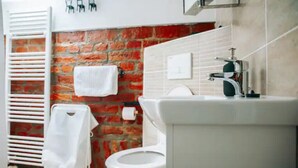 Ein Badezimmer mit Toilette, Waschbecken und einem Handtuch an einem Halter.