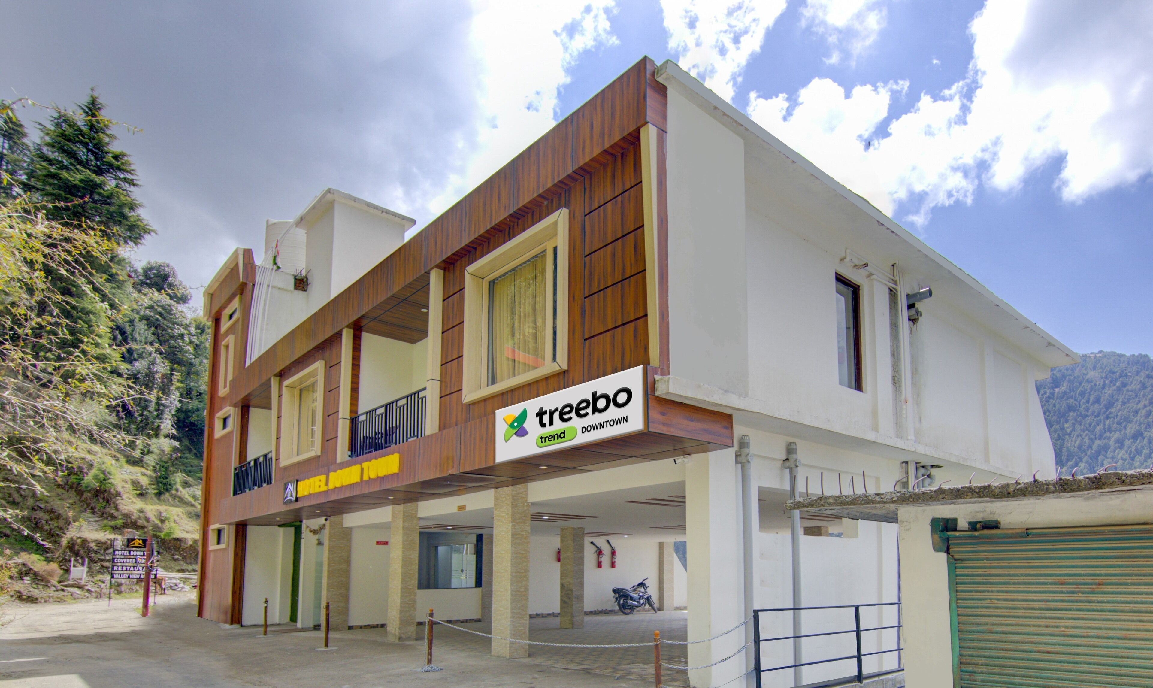 A multi-story building with a sign for 'Treebo Downtown' indicating a hotel or similar establishment.