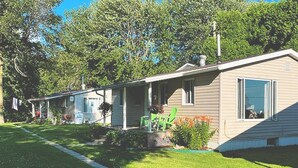 Une rangée de maisons mobiles de plain-pied, avec une pelouse bien entretenue et un ciel dégagé.