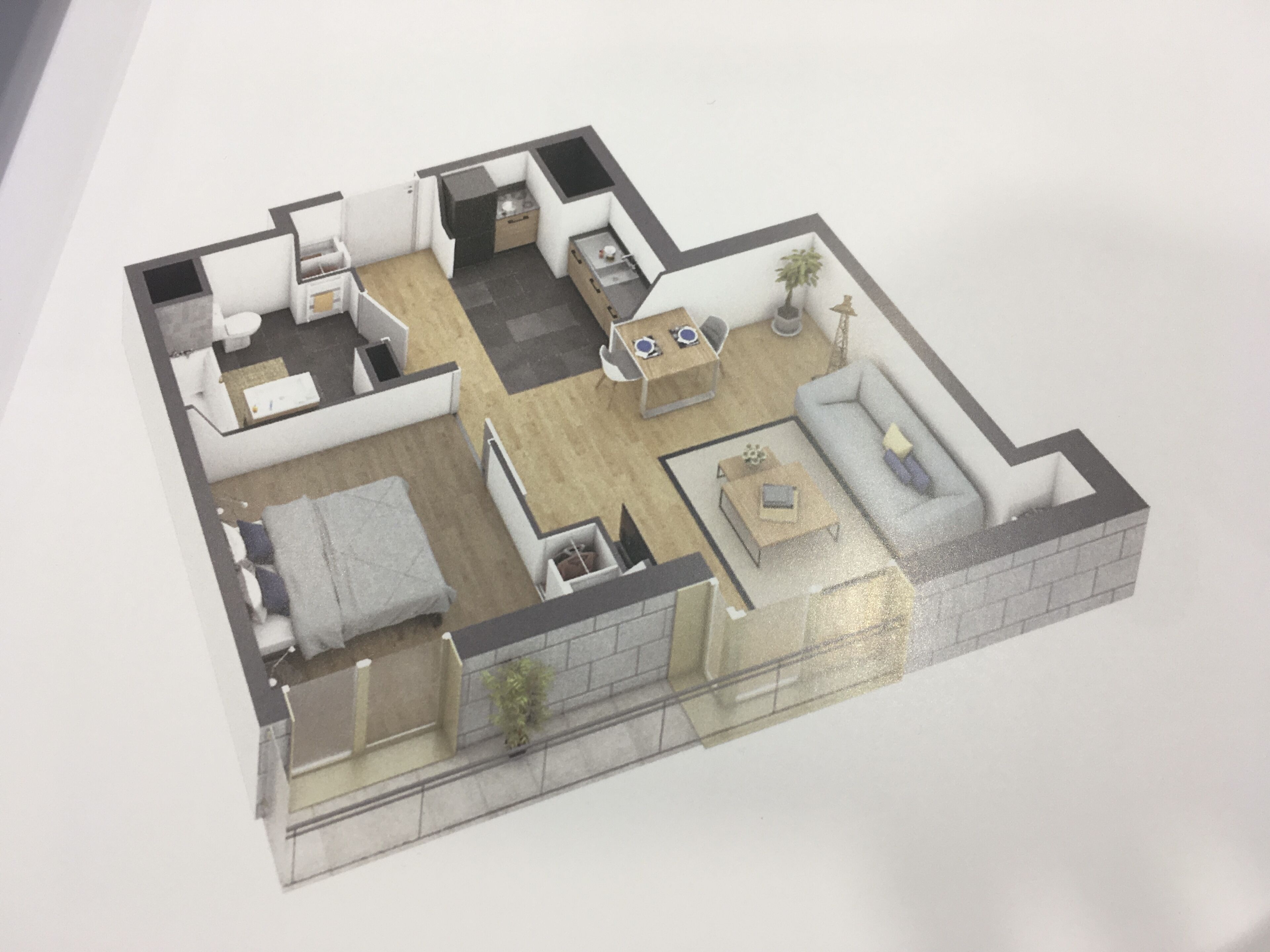 A 3D model of a compact apartment with a living room, kitchen, dining area, and a small balcony.