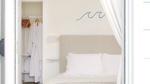 Une chambre à coucher avec un lit, une armoire et un porte-manteau.
