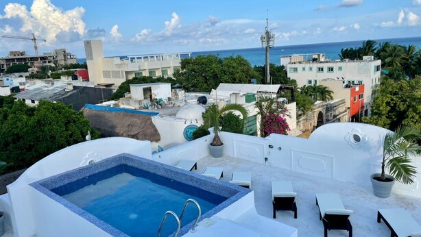 A rooftop pool area with a clear view of the ocean and surrounding buildings. - MAYAB Playa - 5Th. Ave (Playa del Carmen)