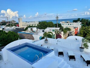 A rooftop pool area with a clear view of the ocean and surrounding buildings. - MAYAB Playa - 5Th. Ave (Playa del Carmen)