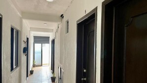 A hallway with tiled flooring, potted plants, and doors leading to rooms. - MAYAB Playa - 5Th. Ave (Playa del Carmen)