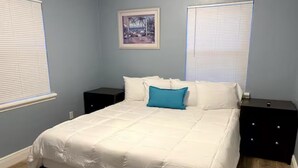 Un dormitorio con una cama grande, dos mesitas de noche y un cuadro enmarcado en la pared.