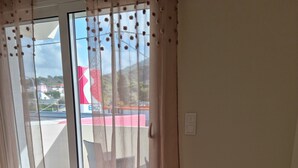 Una habitación con una mesa de comedor, una silla y un florero con flores.