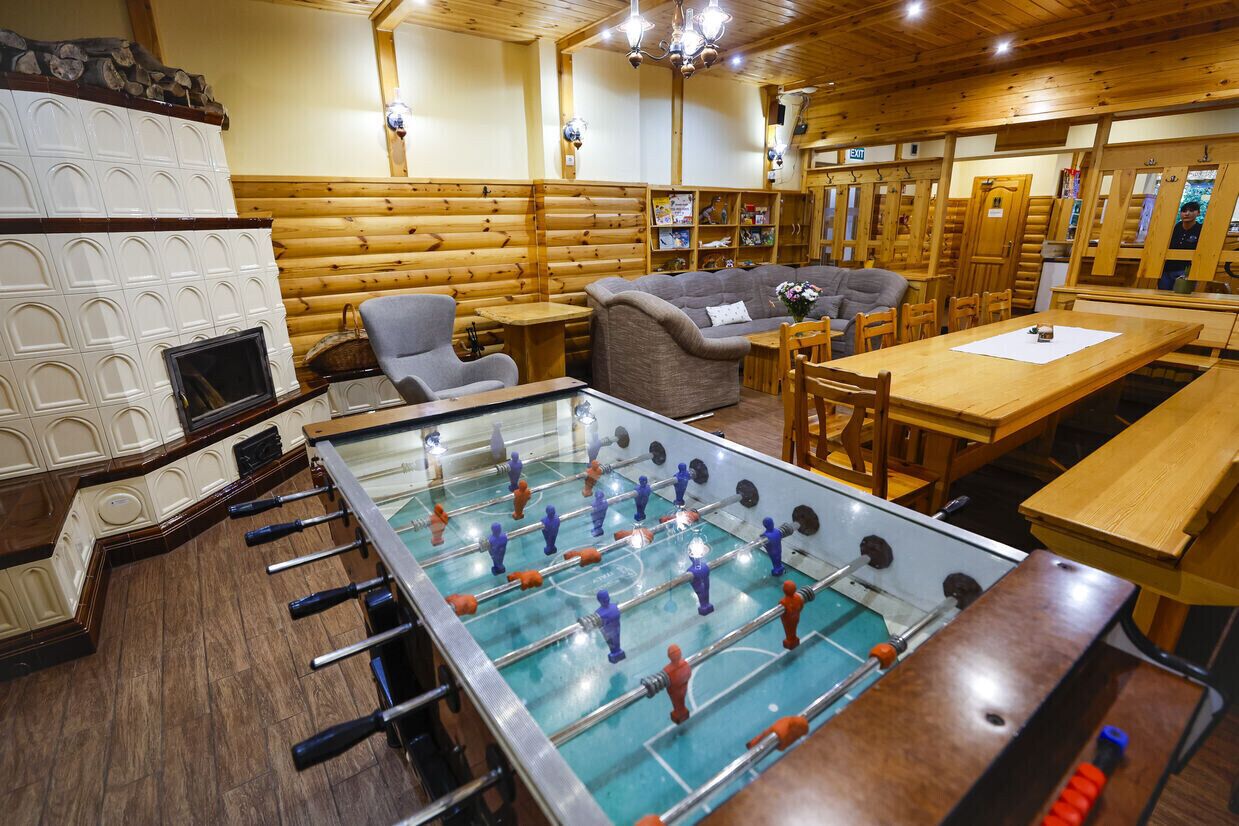 Habitació acollidora amb taula de futbolí, mobles de fusta i una llar de foc.