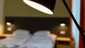 A room with a bed, a bedside table, and a lamp.