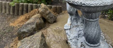 Una fuente de piedra con estatua de león en un jardín.