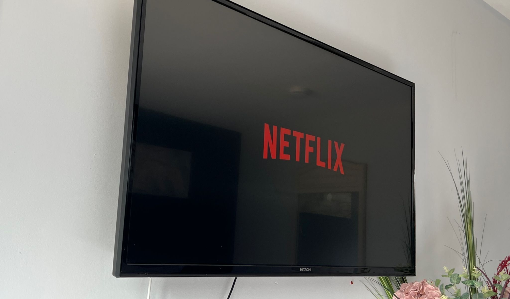 Un televisor de pantalla plana montado en la pared con el logotipo de Netflix en su pantalla.