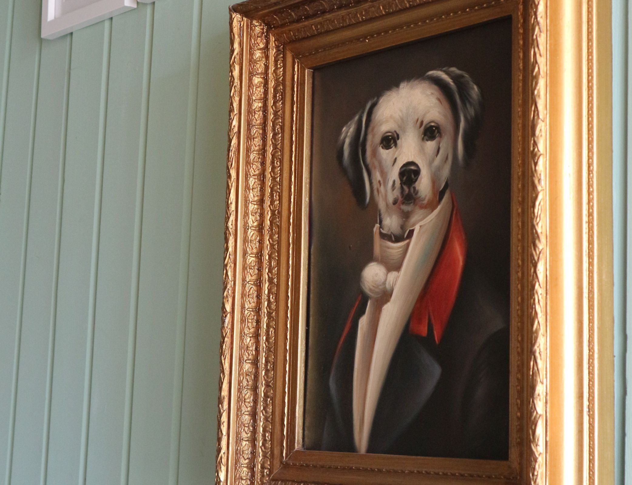 A framed portrait of a dog in formal attire.