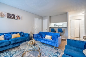 Relax in this stylish living room with a sofa, coffee table, and kitchen view.