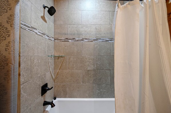 A bathroom with a shower, a bathtub, and a glass shelf. - Rocky Raccoon Cabin, Broken Bow, Hochatown, Beavers Bend (McCurtain County)