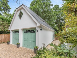 Un petit bâtiment blanc avec une porte verte et une petite fenêtre.