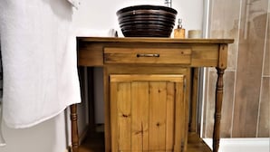 A wooden vanity with a sink, a drawer, and a cabinet.
